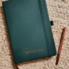 Cuaderno Lauh Editorial - tapa dura verde con logo dorado y bolígrafo