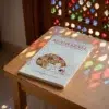 El libro de la oración para niños - Al Ghazali de Abu Hamid Al-Gazali (Algazel), sobre una mesa de madera con la sombra de una celosía