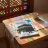 El libro de la peregrinación para jóvenes - Al Ghazali de Abu Hamid Al-Gazali (Algazel), sobre una mesa de madera con la sombra de una celosía