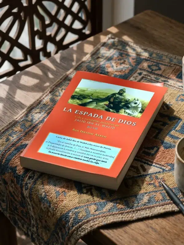 La Espada de Dios, la vida de Jalid Ibn Al Walid de Aga Ibrahim Akram, sobre una mesa de madera con la sombra de una celosía