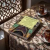 Libro 23 - El sometimiento de las dos pasiones de Imam Al-Gazzali, sobre una mesa de madera con la sombra de una celosía
