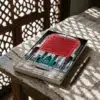 Libro 26 - La reprobación del apego al mundo terrenal de Imam Al-Gazzali, sobre una mesa de madera con la sombra de una celosía