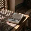 Libro 29 - La reprobación de la soberbia y la vanidad de Imam Al-Gazzali, sobre una mesa de madera con la sombra de una celosía