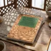 Libro 5 - Los misterios de la caridad de Imam Al-Gazzali, sobre una mesa de madera con la sombra de una celosía