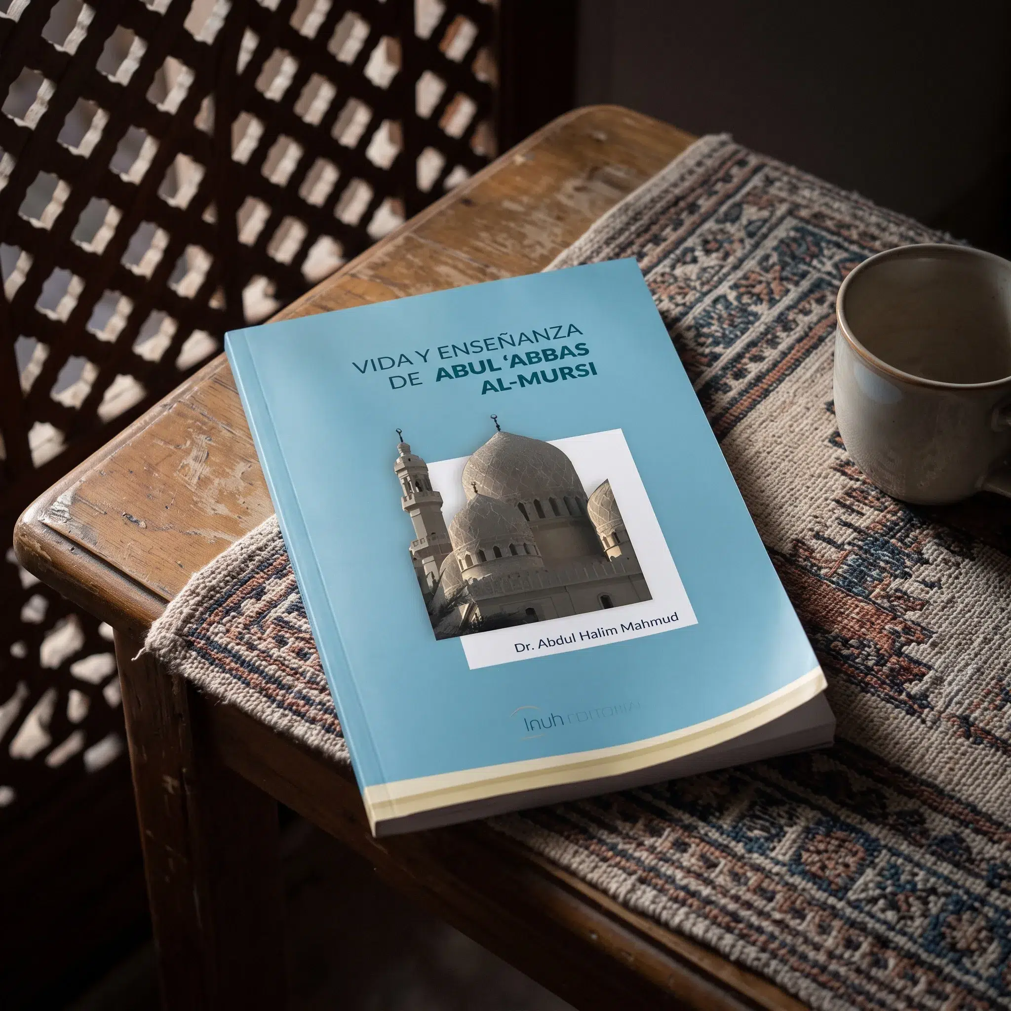 Vida y enseñanza de Abul 'Abbas Al-Mursi de Abdul Halim Mahmud, sobre una mesa de madera con la sombra de una celosía