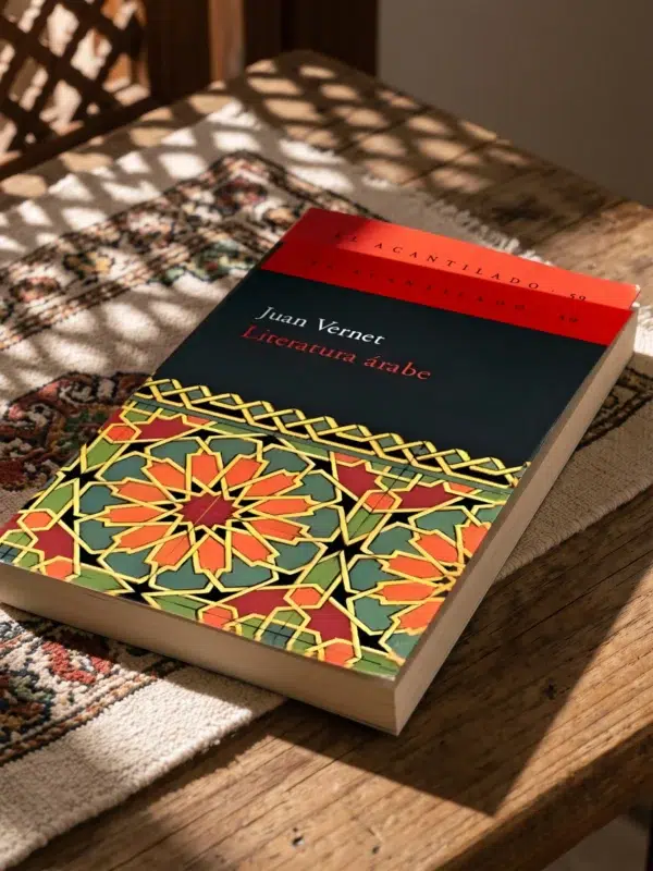 Literatura árabe de Juan Vernet, sobre una mesa de madera con la sombra de una celosía