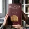 Unas manos sostienen Los Cuarenta Hadices del Imam al-Nawawi, con comentario de Ibn Daqiq al-'Id