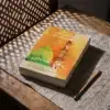 Los Jardines de los Justos (Edición Bilingüe) de Imam An-Nawawi, sobre una mesa de madera con la sombra de una celosía